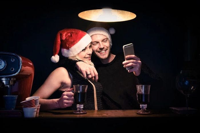 Flickvän som tar selfie med pojkvännen under jul